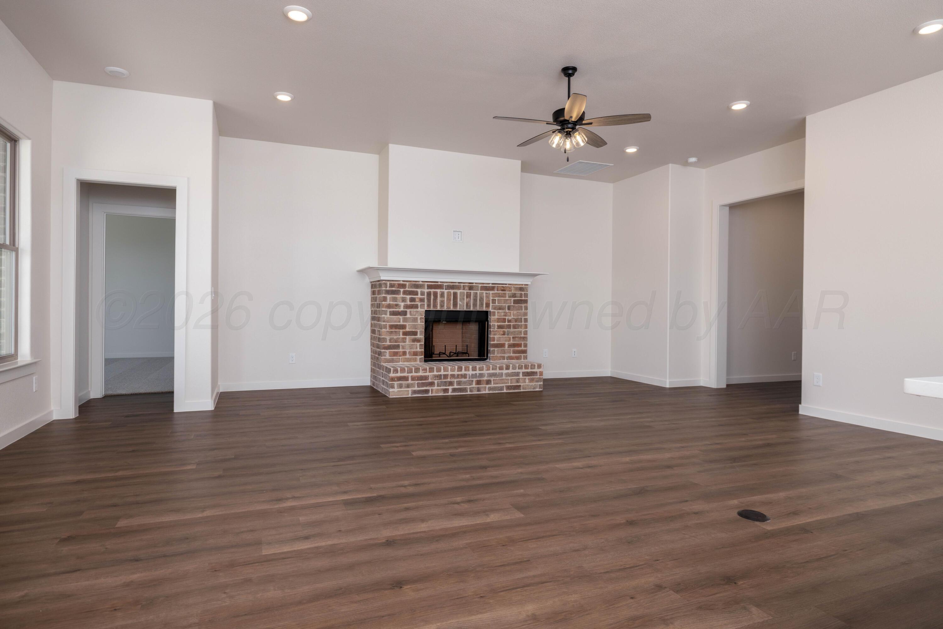 3107 Bluejay Road Amarillo, TX 79124 - Photo 5 of 14 a view of an empty room with wooden floor fireplace and a window