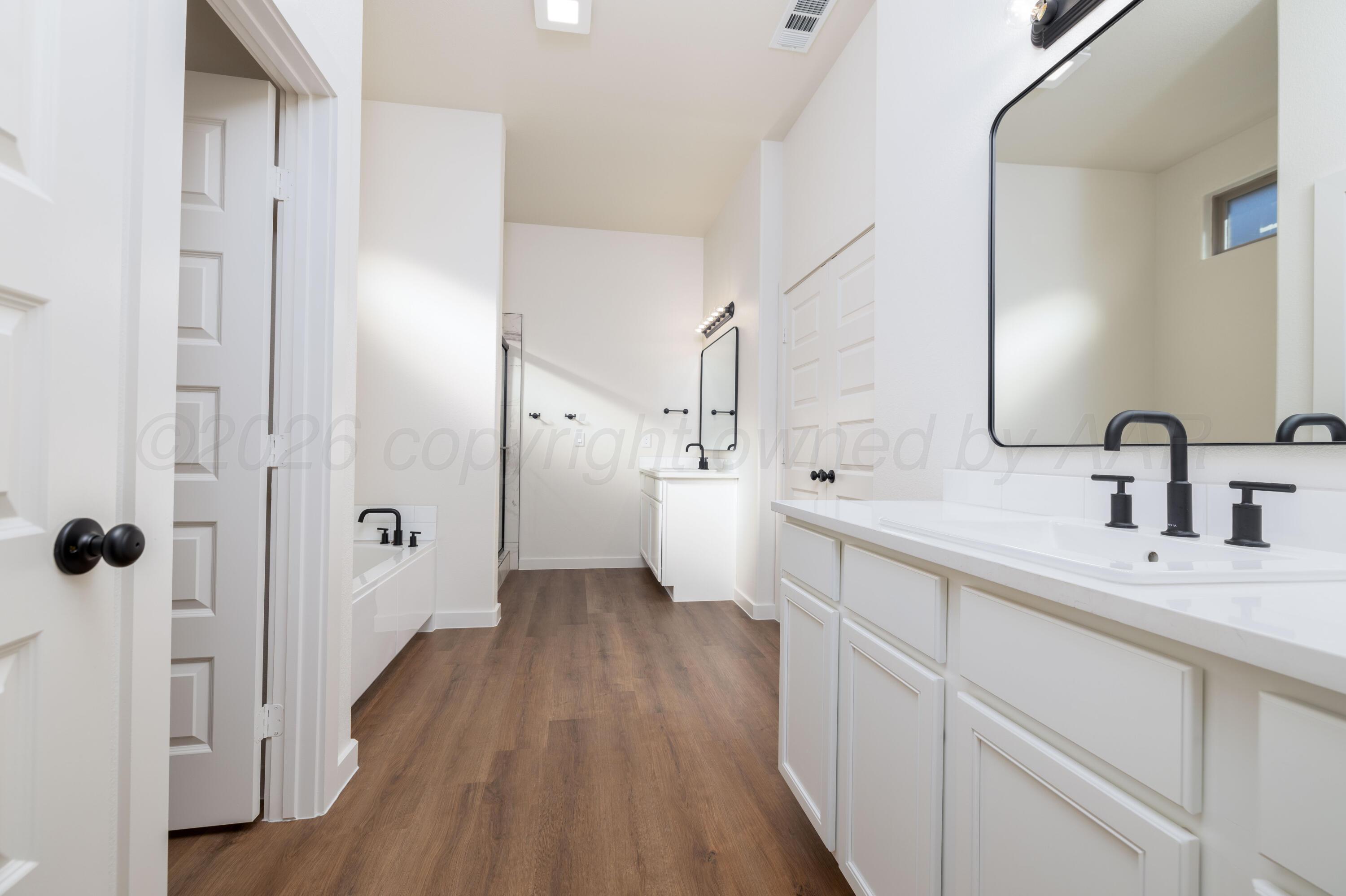 3107 Bluejay Road Amarillo, TX 79124 - Photo 6 of 14 a spacious bathroom with a sink a mirror a toilet and shower