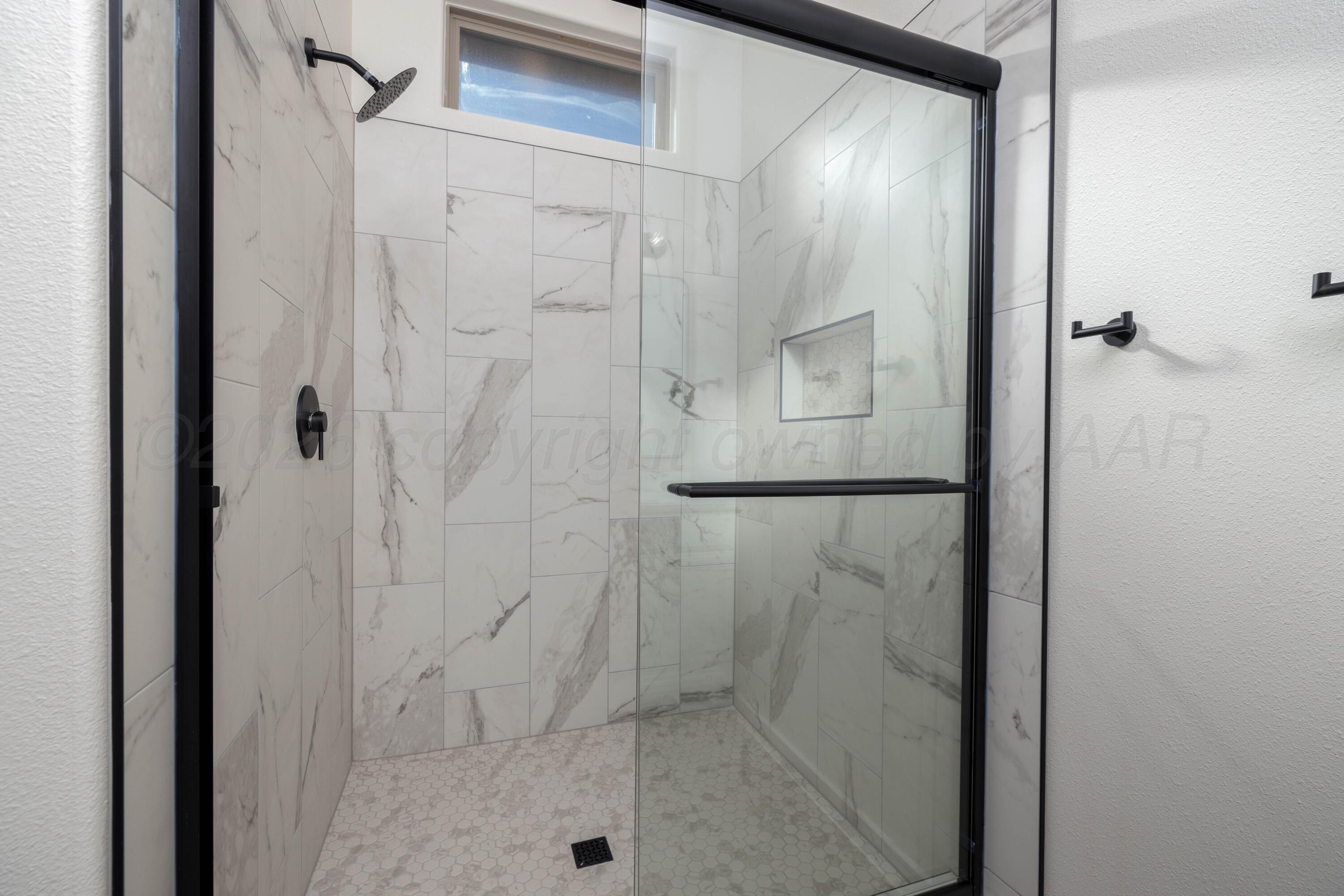 3107 Bluejay Road Amarillo, TX 79124 - Photo 10 of 14 a bathroom with a glass shower door
