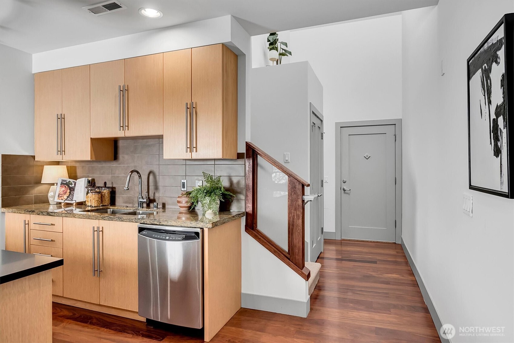121 South Jackson Street, Unit 4 Seattle, WA 98104 - Photo 5 of 38 a kitchen with stainless steel appliances granite countertop a refrigerator a sink dishwasher a stove with wooden floor and cabinets