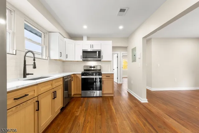 a kitchen with cabinets a sink and steel appliances