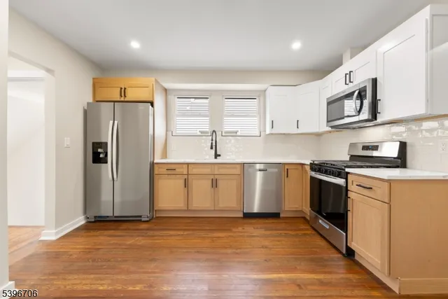 a kitchen with stainless steel appliances granite countertop a refrigerator and a stove top oven