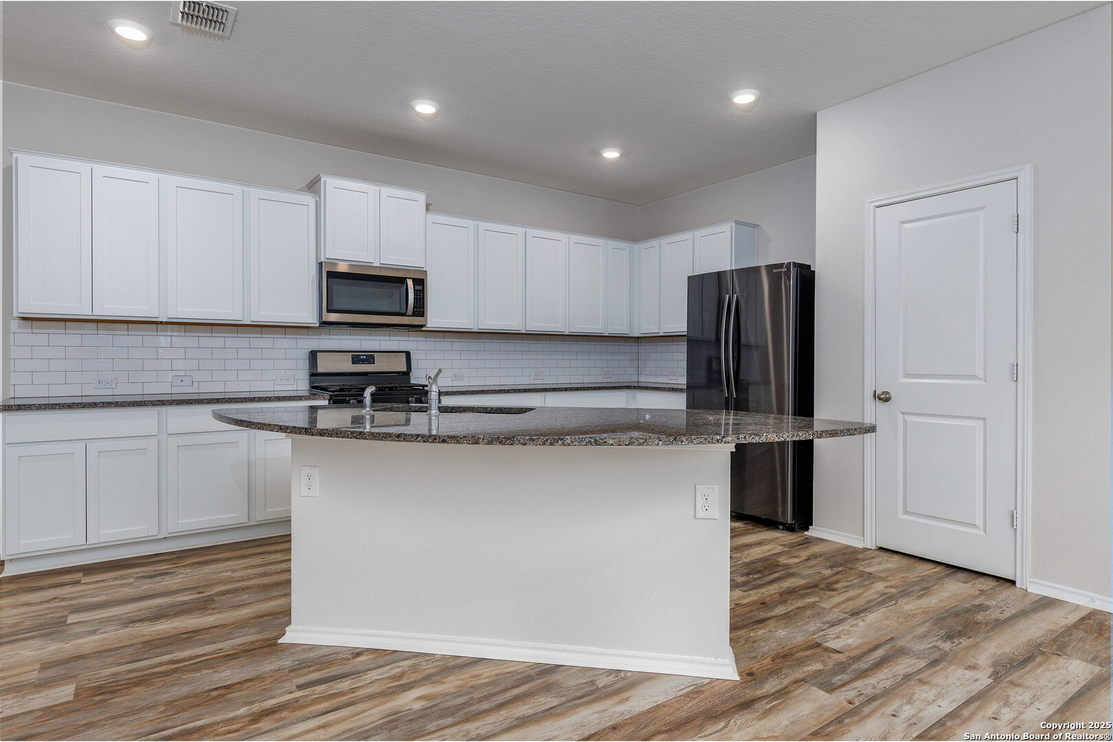 29714 Spring Copper Bulverde, TX 78163 - Photo 8 of 26 a kitchen with stainless steel appliances granite countertop a refrigerator sink and white cabinets