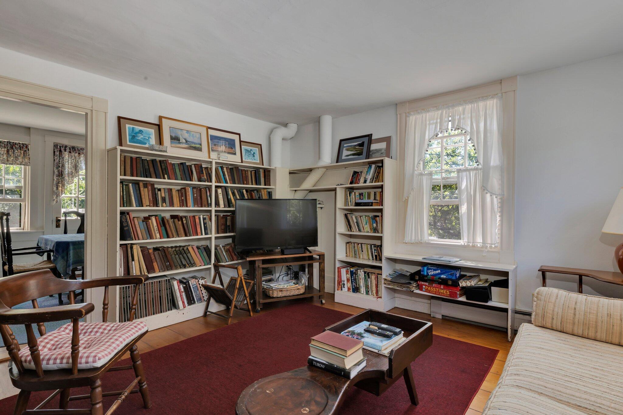 64 Depot Road Truro, MA 02666 - Photo 27 of 53 a living room with furniture a rug and a bookshelf