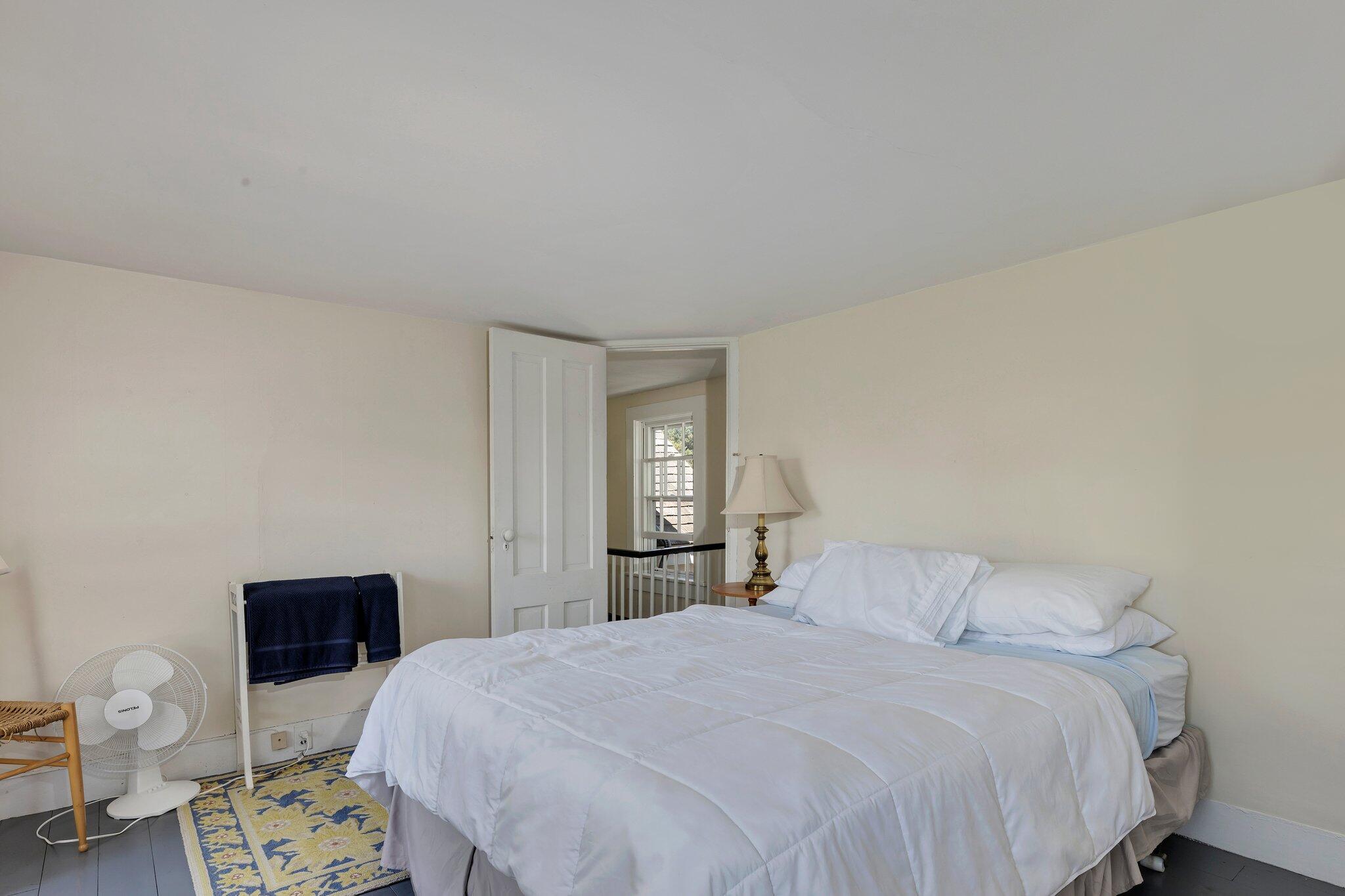 64 Depot Road Truro, MA 02666 - Photo 40 of 53 a bedroom with a bed and a lamp with wooden floor