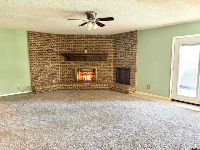 a view of empty room with fireplace and fan