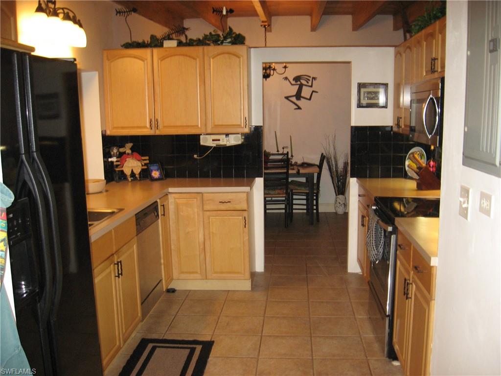 5150 Sand Dollar Lane Naples, FL 34103 - Photo 11 of 16 a kitchen with a sink appliances and cabinets