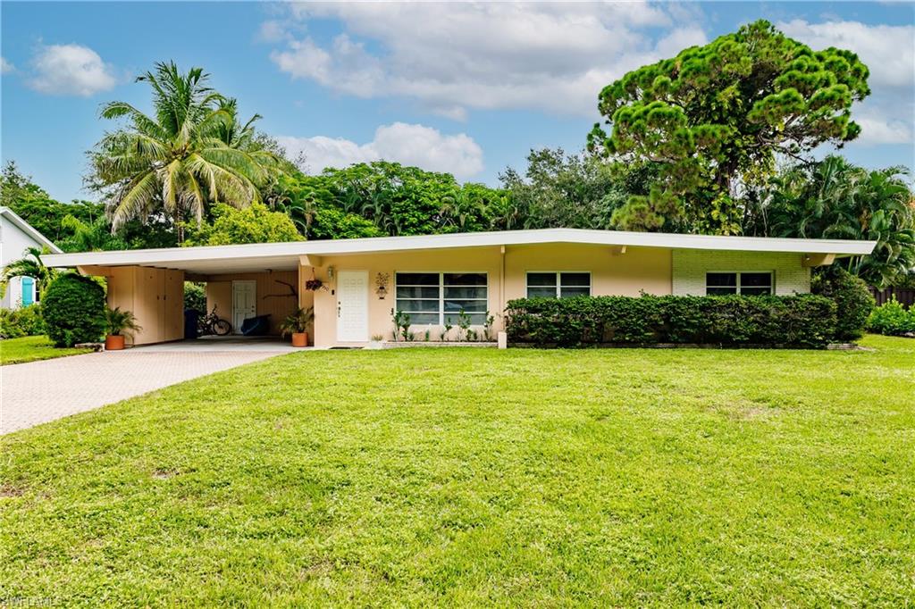 5150 Sand Dollar Lane Naples, FL 34103 - Photo 16 of 16 a view of an house with backyard space and garden