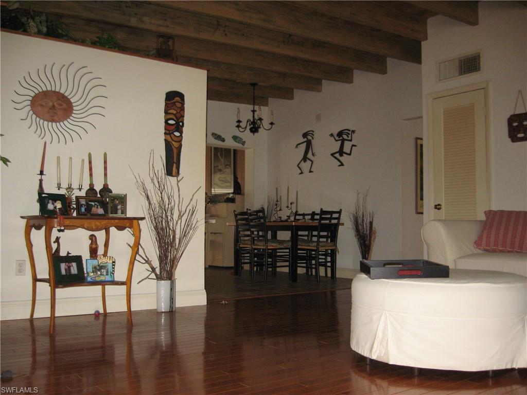 5150 Sand Dollar Lane Naples, FL 34103 - Photo 2 of 16 a view of a dining room with furniture and wooden floor