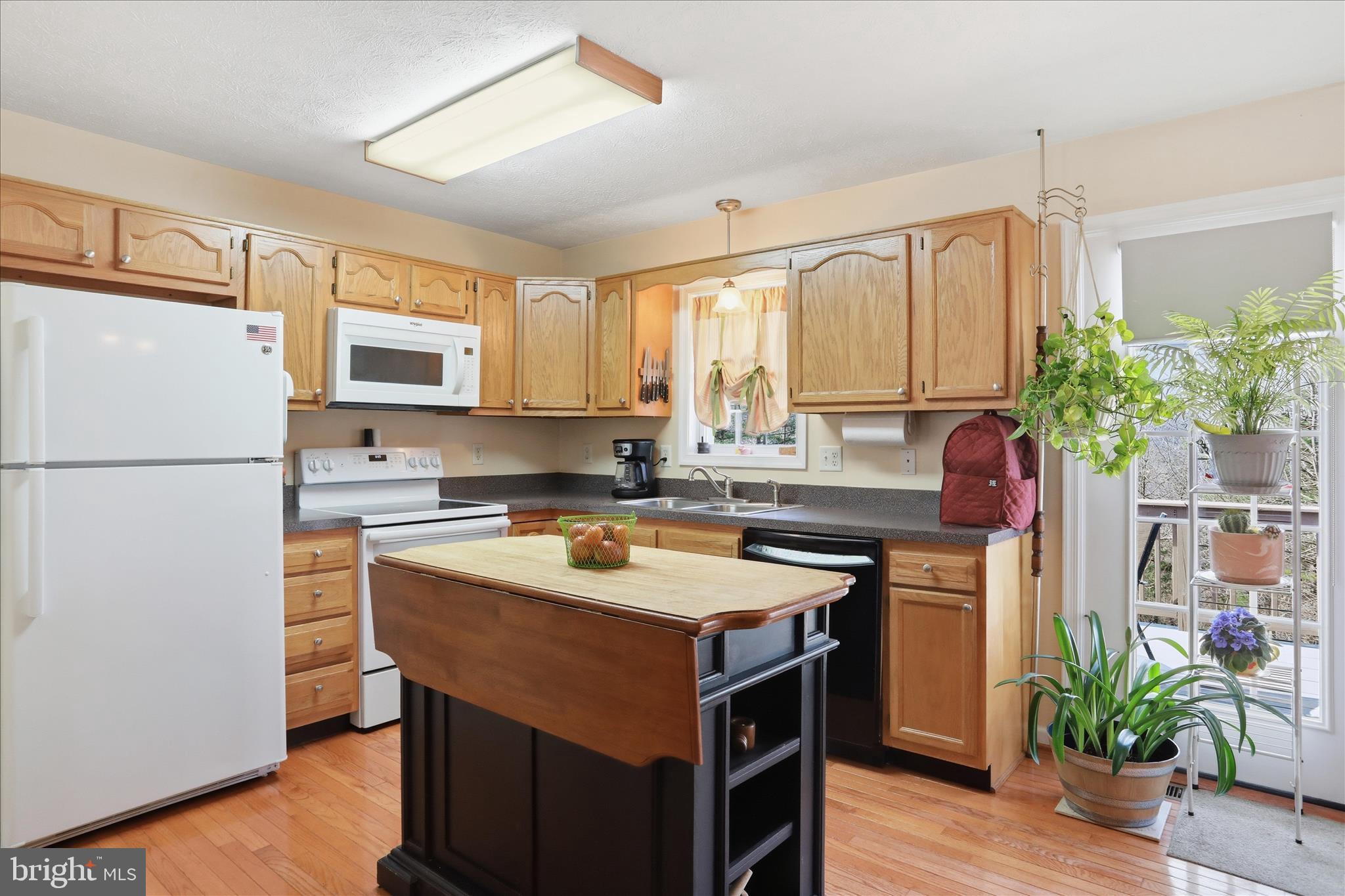 1158 Drummer Hill Road Front Royal, VA 22630 - Photo 10 of 36 a kitchen with a refrigerator a sink dishwasher and white cabinets with wooden floor