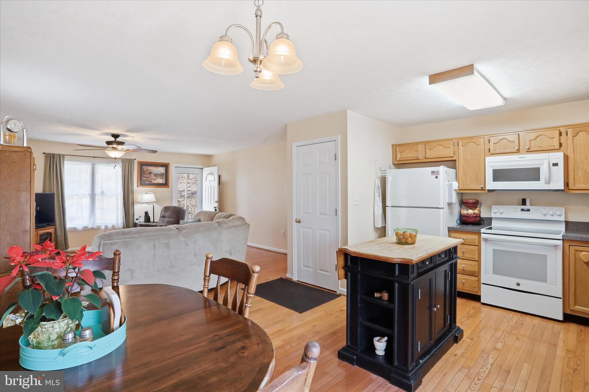 1158 Drummer Hill Road Front Royal, VA 22630 - Photo 9 of 36 a kitchen with stainless steel appliances kitchen island granite countertop a table chairs in it and wooden floors