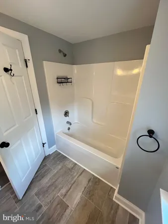 a bathroom with a tub sink and a mirror