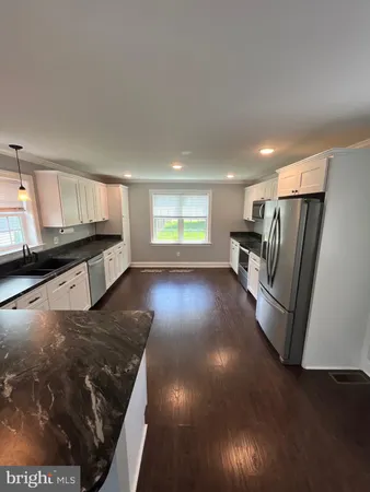 a kitchen with stainless steel appliances granite countertop a refrigerator a stove a sink and a microwave