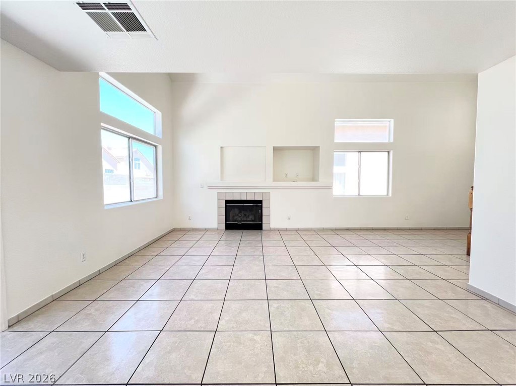 8284 West Rochelle Avenue Las Vegas, NV 89147 - Photo 7 of 29 A spacious living area features high ceilings, a cozy fireplace, and abundant natural light.
