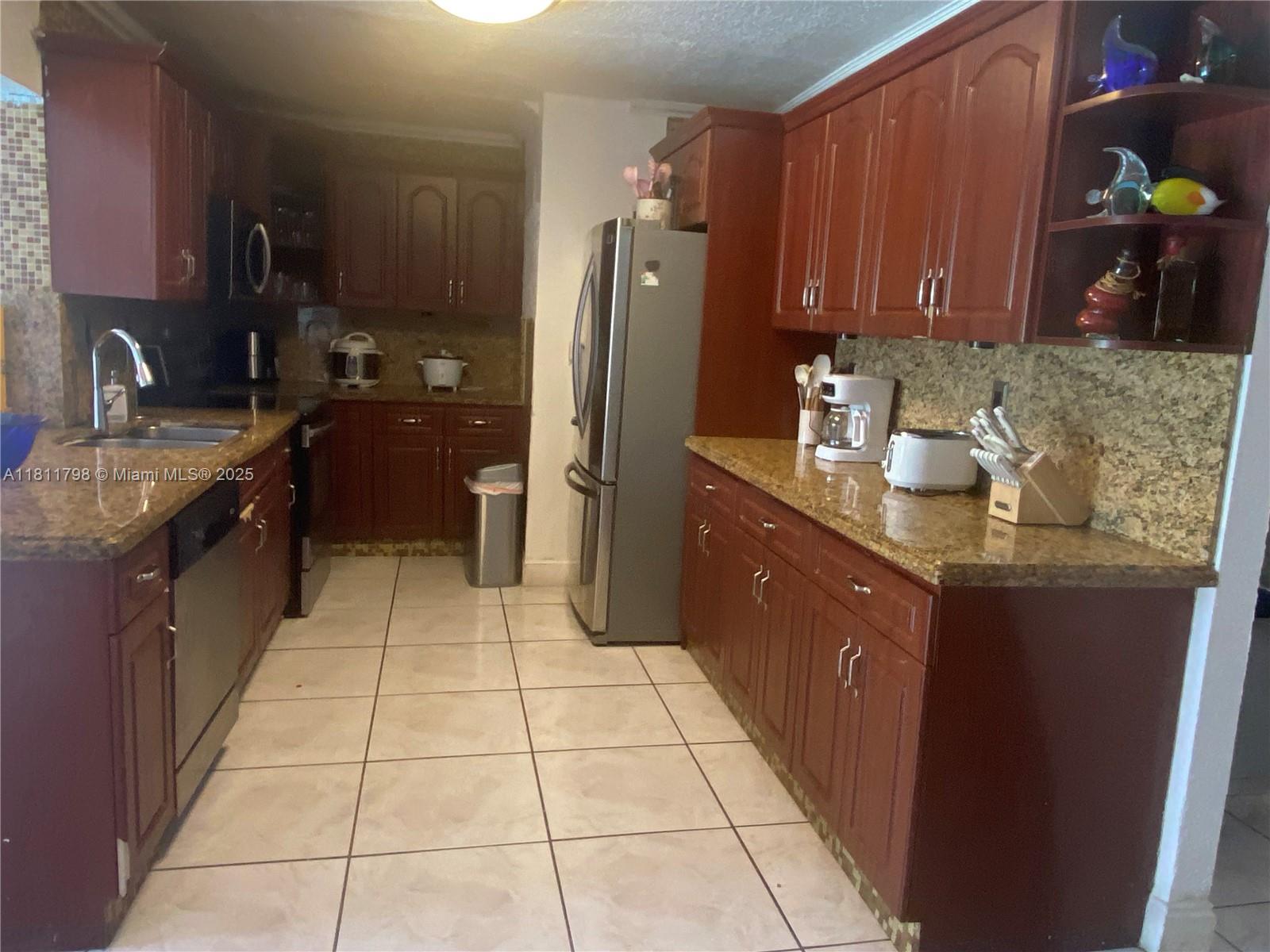 13360 Southwest 43rd Street Miami, FL 33175 - Photo 5 of 12 a kitchen with stainless steel appliances granite countertop a sink stove and refrigerator