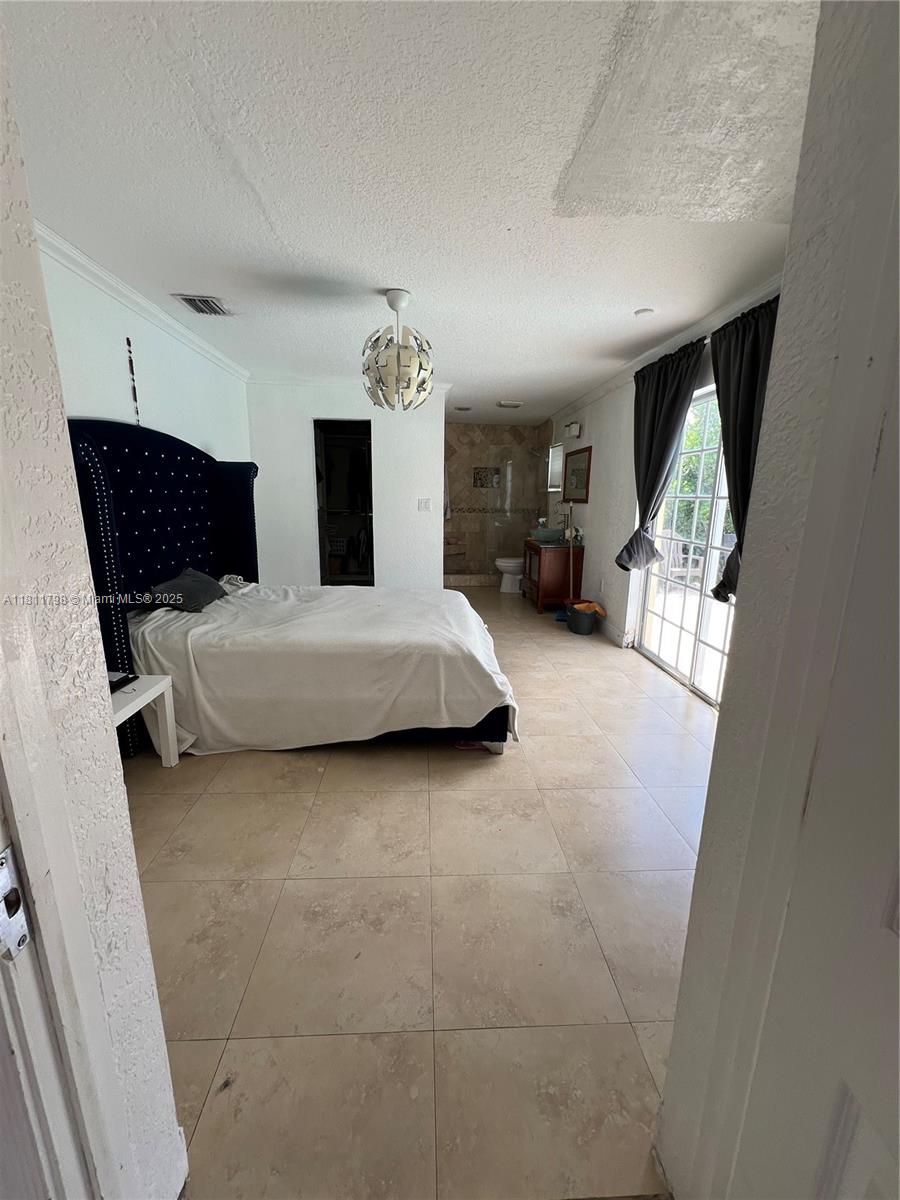 13360 Southwest 43rd Street Miami, FL 33175 - Photo 6 of 12 a bedroom with a bed and lamp