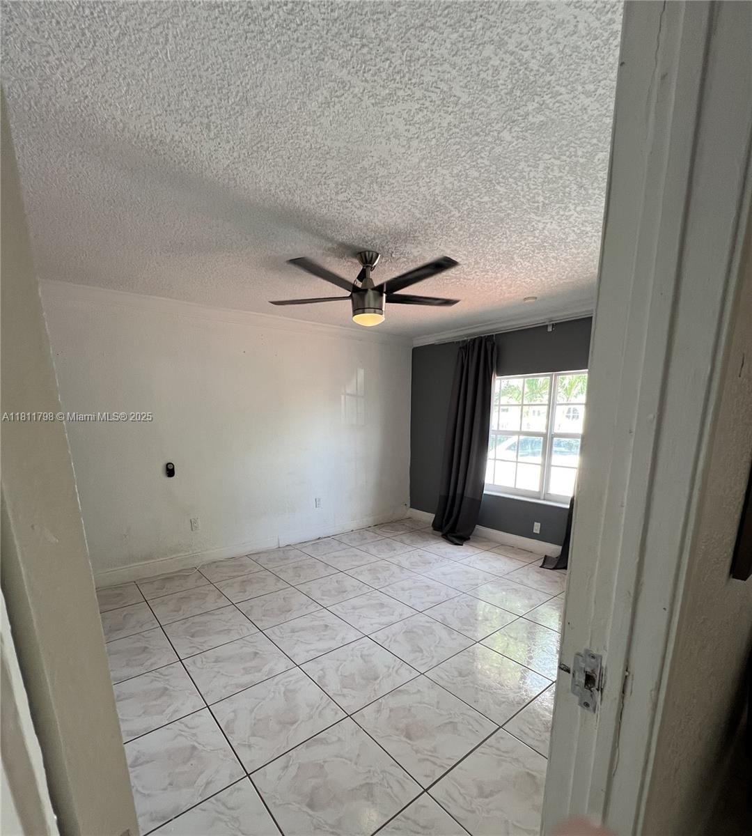 13360 Southwest 43rd Street Miami, FL 33175 - Photo 8 of 12 a view of a livingroom with a ceiling fan and window