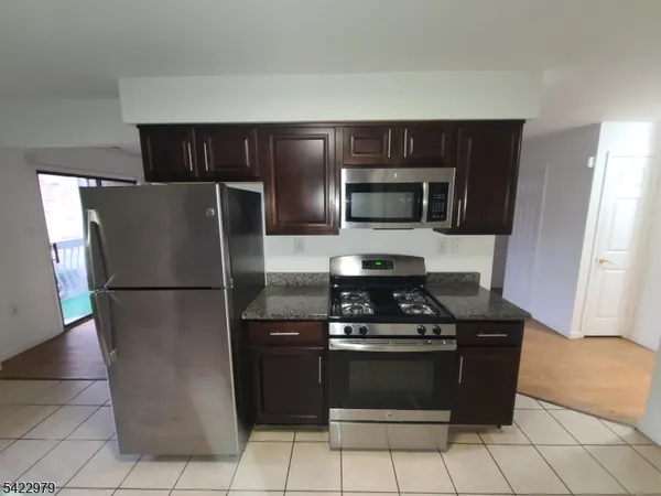 a kitchen with a refrigerator and a stove top oven