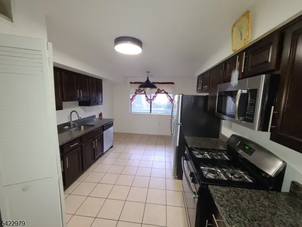 a kitchen with a refrigerator and a stove top oven