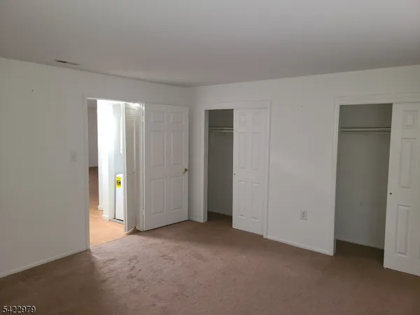 an empty room with closet and windows