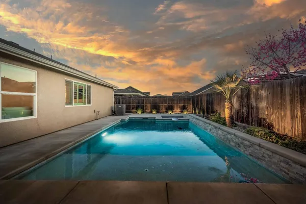 a house view with swimming pool in front of it