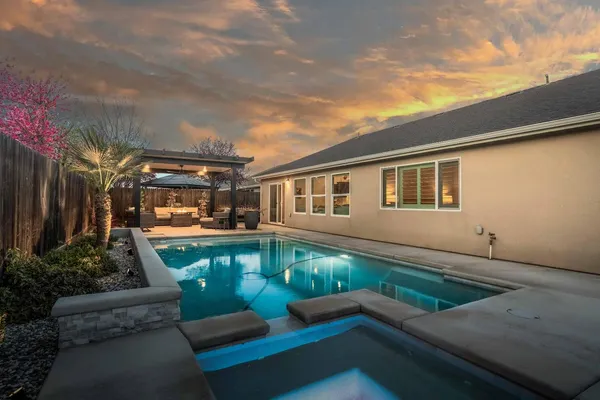 a view of a house with backyard and sitting area