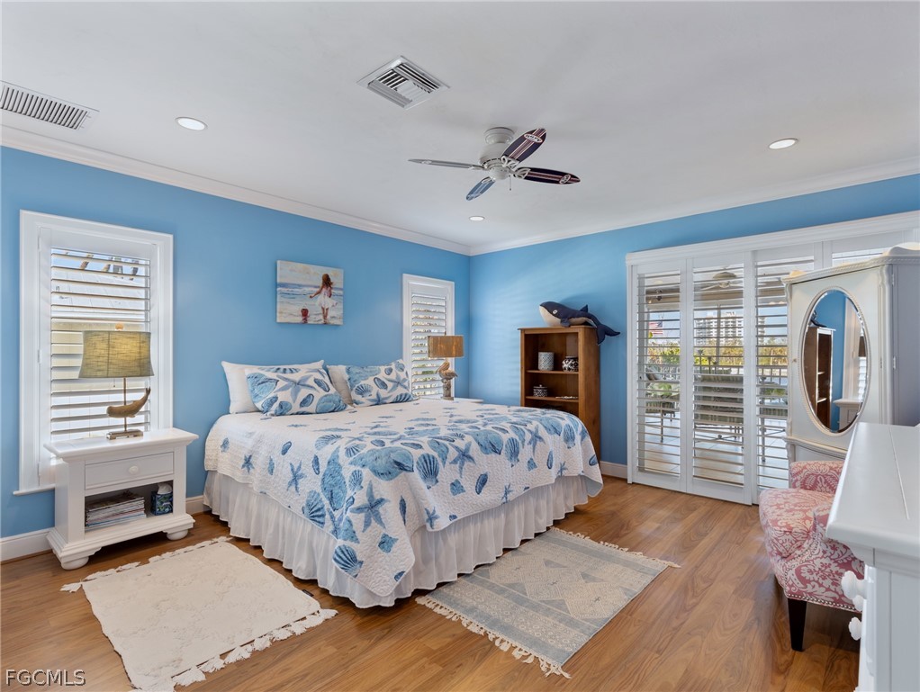 921 Prescott Street Fort Myers Beach, FL 33931 - Photo 18 of 50 a bedroom with a large bed a flat tv screen and dresser