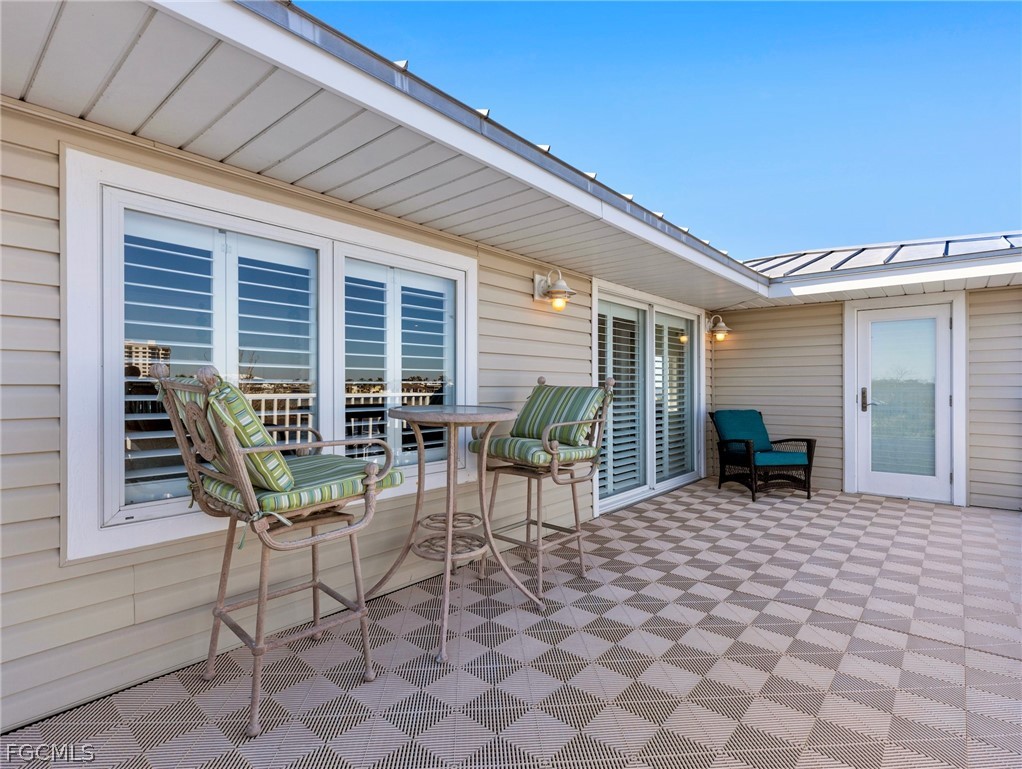 921 Prescott Street Fort Myers Beach, FL 33931 - Photo 24 of 50 a view of a patio with a table and chairs and a barbeque