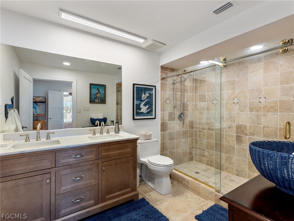 921 Prescott Street Fort Myers Beach, FL 33931 - Photo 34 of 50 a bathroom with a double vanity sink toilet and shower