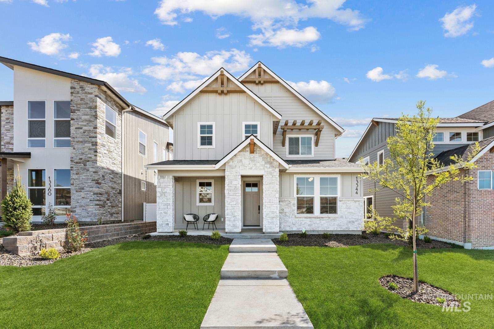 13344 North Spring Creek Way Boise, ID 83714 - Photo 1 of 39 View of front facade featuring board and batten siding, stone siding, and a front lawn