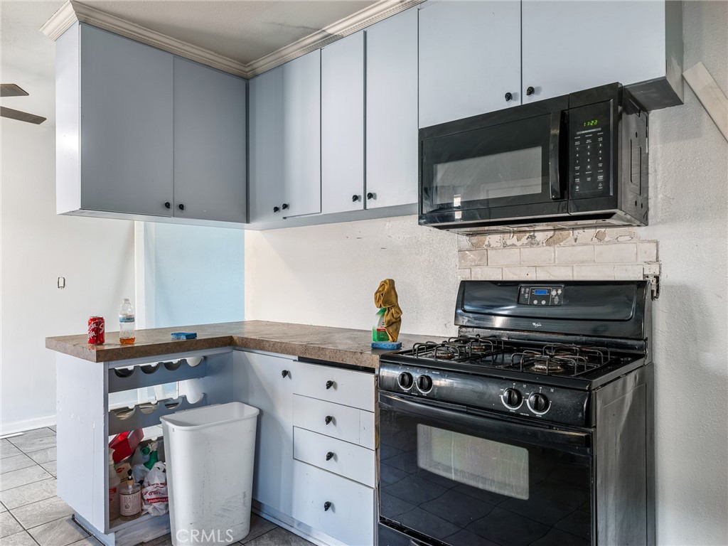 16003 Chestnut Street Hesperia, CA 92345 - Photo 12 of 28 a kitchen with stainless steel appliances a sink dishwasher stove and microwave with wooden cabinets