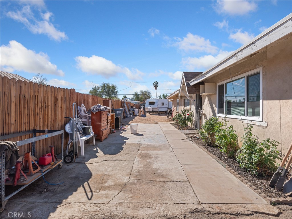16003 Chestnut Street Hesperia, CA 92345 - Photo 2 of 28 a view of a patio with table and chairs potted plants with wooden fence