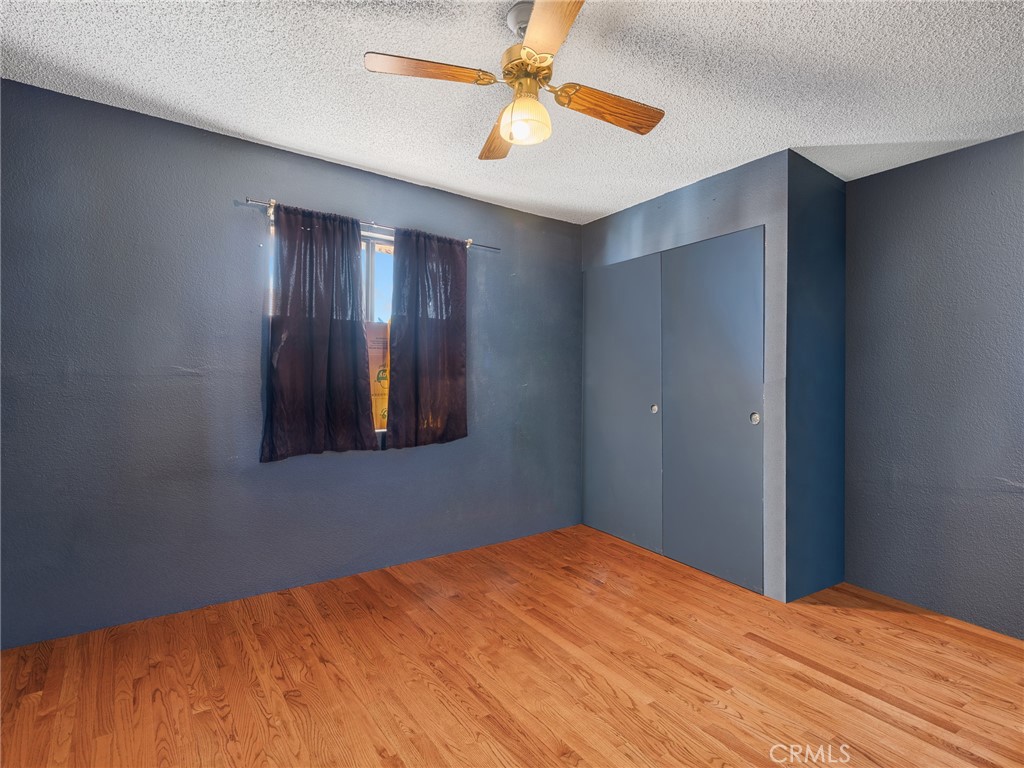 16003 Chestnut Street Hesperia, CA 92345 - Photo 21 of 28 a bedroom with a bed and a chandelier fan