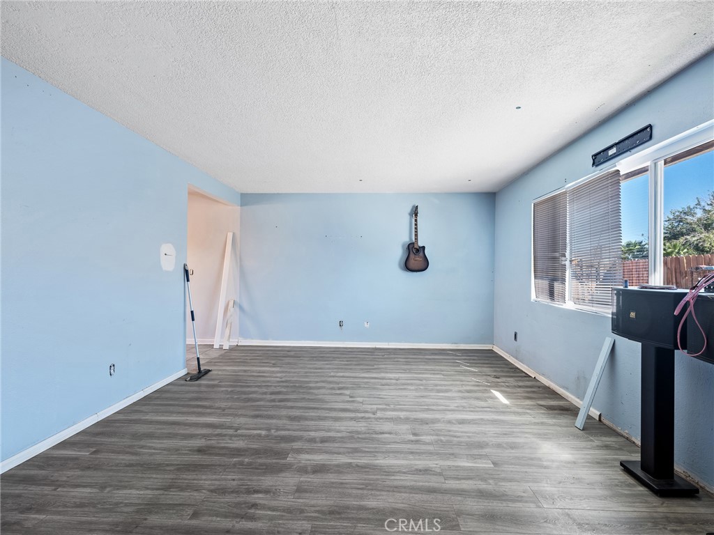 16003 Chestnut Street Hesperia, CA 92345 - Photo 6 of 28 a view of an empty room with wooden floor and a window