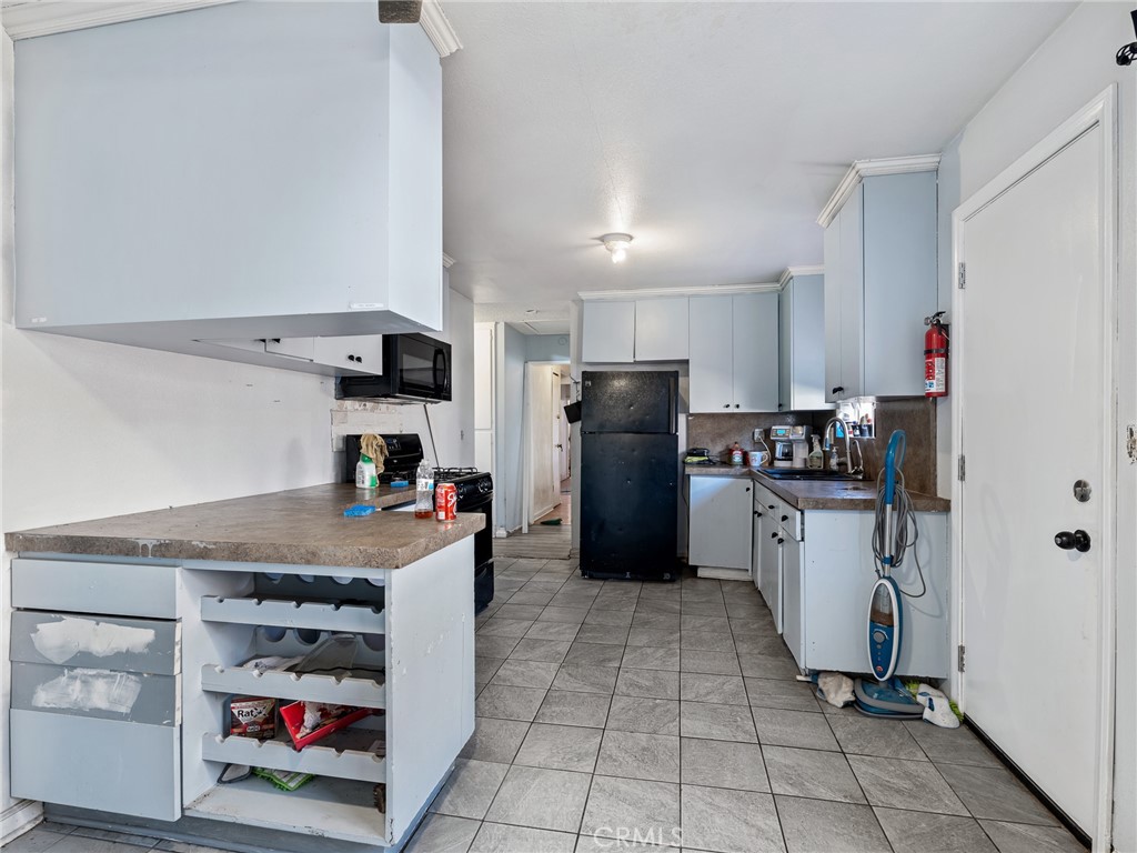 16003 Chestnut Street Hesperia, CA 92345 - Photo 9 of 28 a kitchen with a refrigerator a stove and cabinets