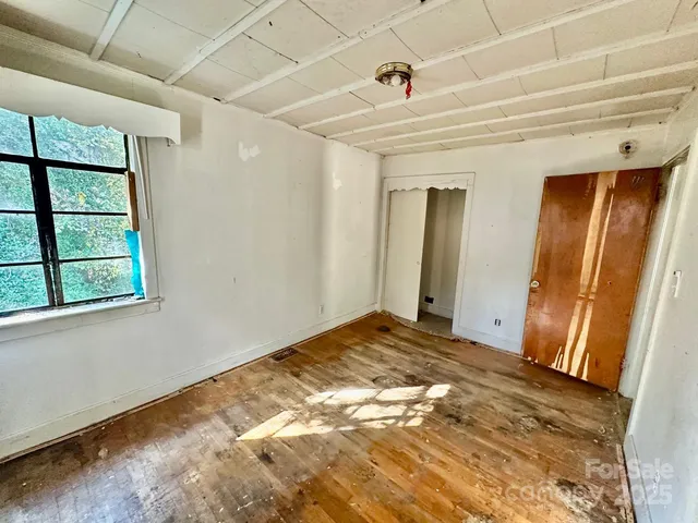 a view of a hallway with wooden floor and door