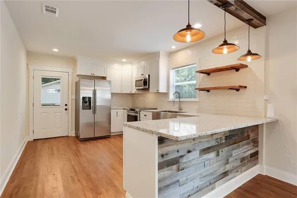 a kitchen with stainless steel appliances granite countertop a sink a refrigerator and a stove