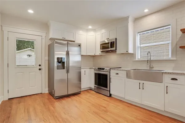 a kitchen with stainless steel appliances a refrigerator sink and microwave