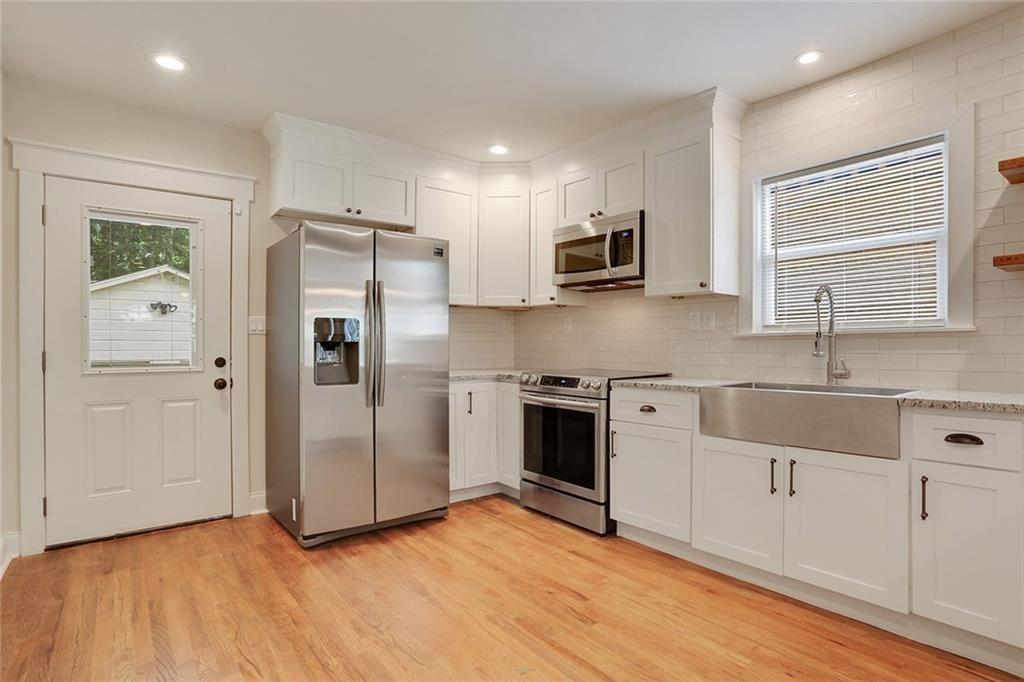 1060 Regent Street Southwest Atlanta, GA 30310 - Photo 14 of 24 a kitchen with stainless steel appliances a refrigerator sink and microwave