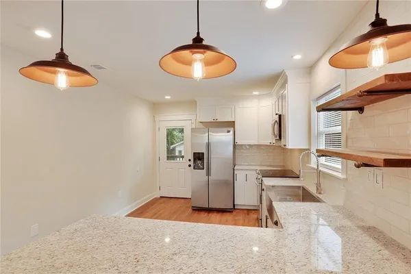 a kitchen with a refrigerator and chandelier