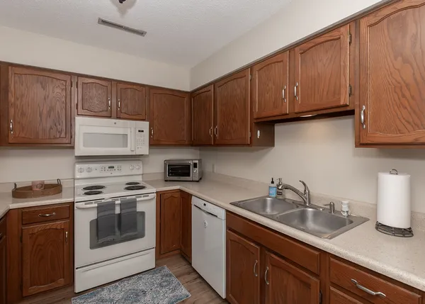 a kitchen with stainless steel appliances granite countertop a sink a stove and cabinets