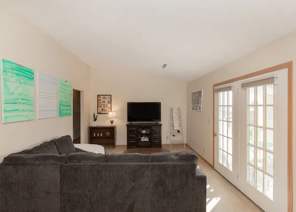 a living room with furniture a flat screen tv and a large window