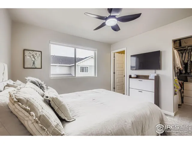 a bedroom with a large bed and a flat tv screen on dresser