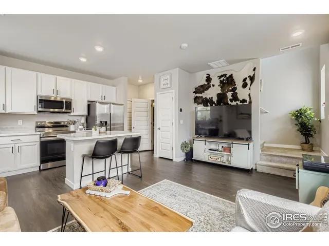 a kitchen with stainless steel appliances kitchen island granite countertop a refrigerator and a stove top oven