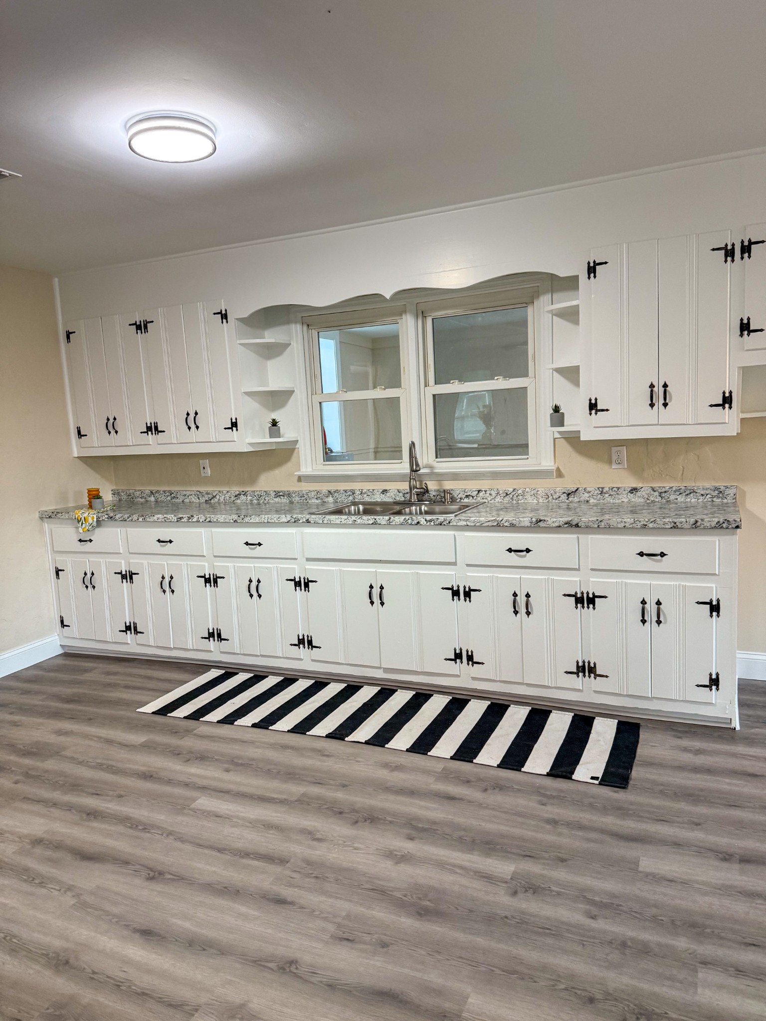 731 Smith Avenue Hohenwald, TN 38462 - Photo 15 of 28 a white kitchen with granite countertop a stove a sink and white cabinets