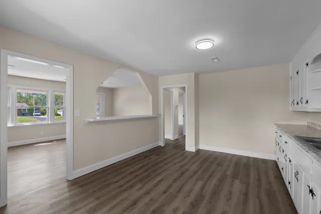 a kitchen with granite countertop a sink window and cabinets