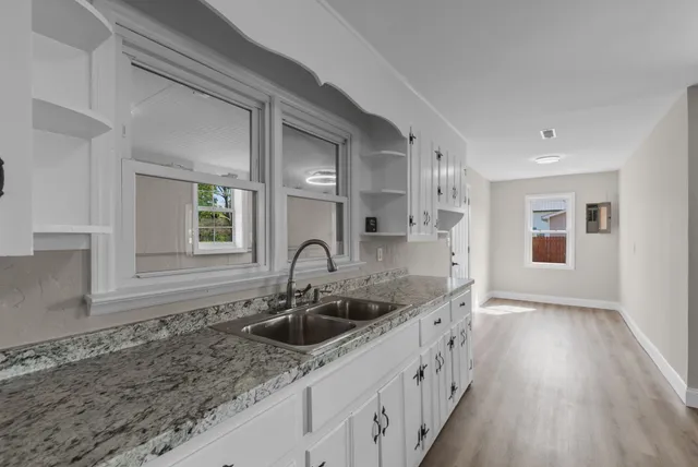 a bed sitting in a bedroom next to a window with lamp