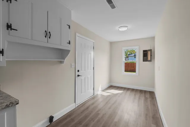 a view of empty room with wooden floor