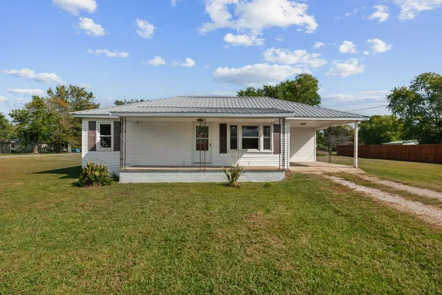 a view of a house with backyard and sitting area