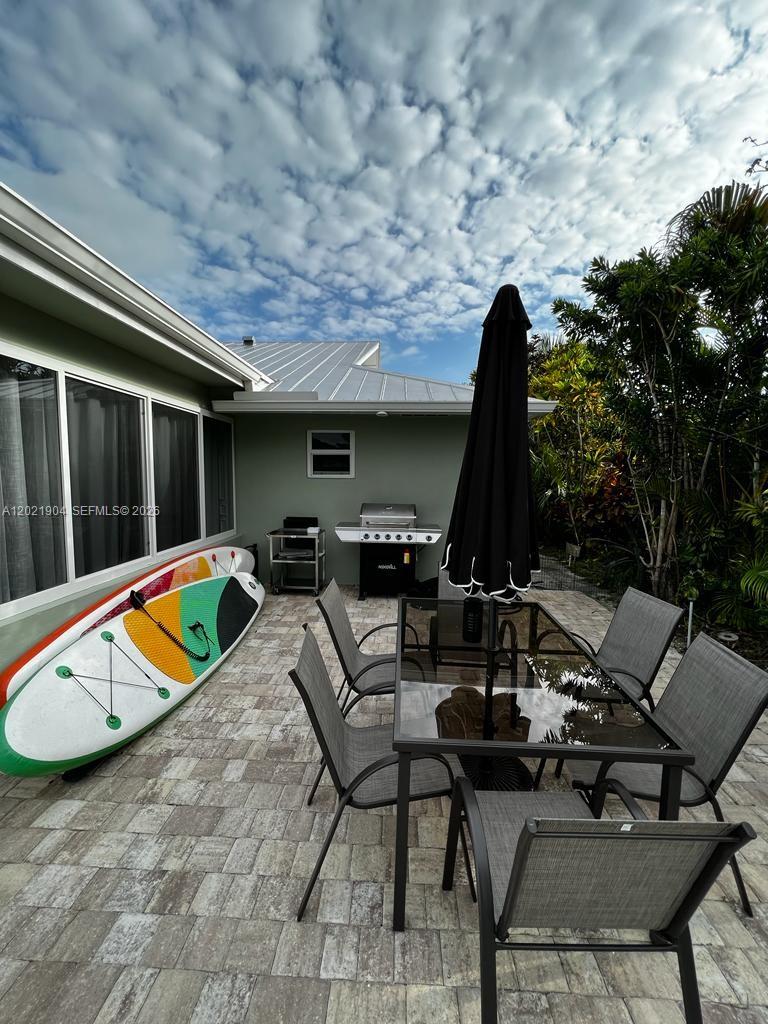 3324 Lakeview Boulevard Delray Beach, FL 33445 - Photo 15 of 36 a view of a swimming pool with chairs and table in a patio